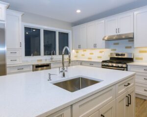 A city kitchen remodel with white cabinets and a stainless steel sink.