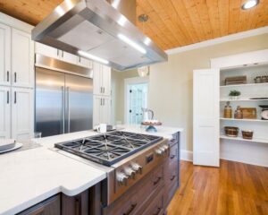 A remodeled kitchen with a stove top and refrigerator in the city.